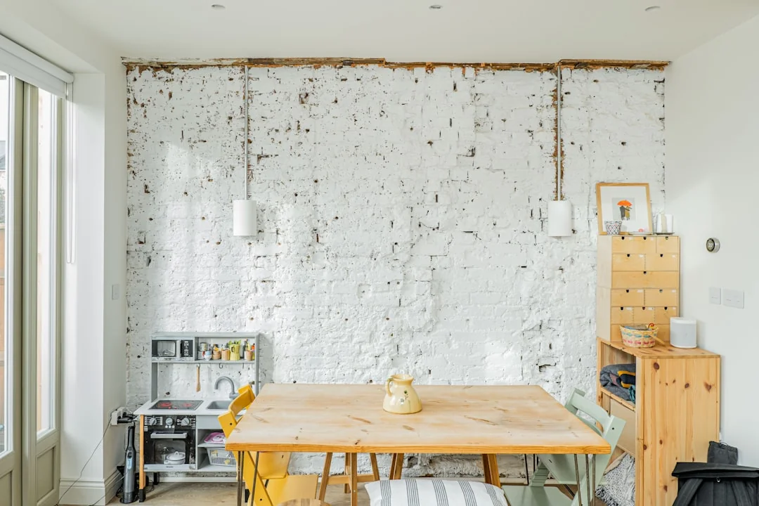 Un couple range des cartons étiquetés dans un salon au style minimaliste, en préparation du jour du déménagement.